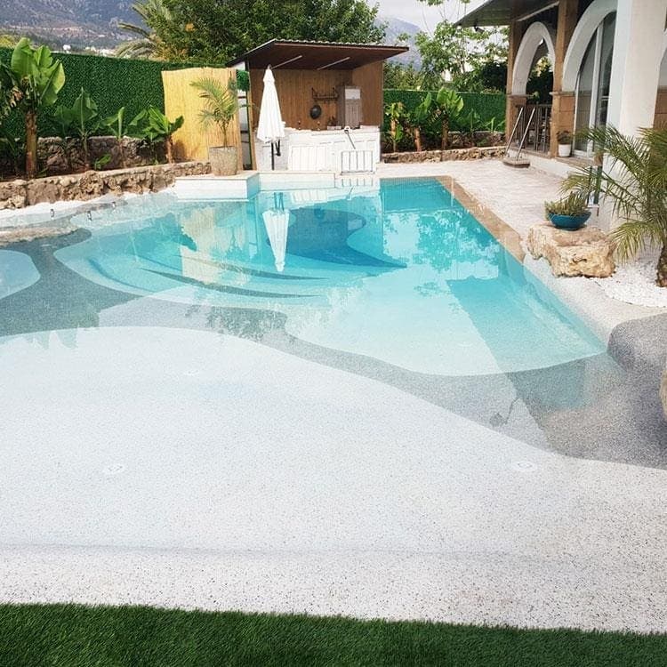 Kumsal girişli Pebbledeck kaplı havuz
